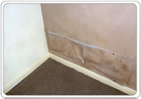 Damp walls causes wallpaper to fall away